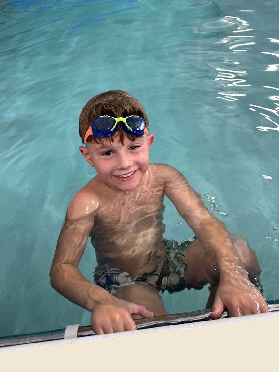 Child smiling at the side of the Making Waves pool